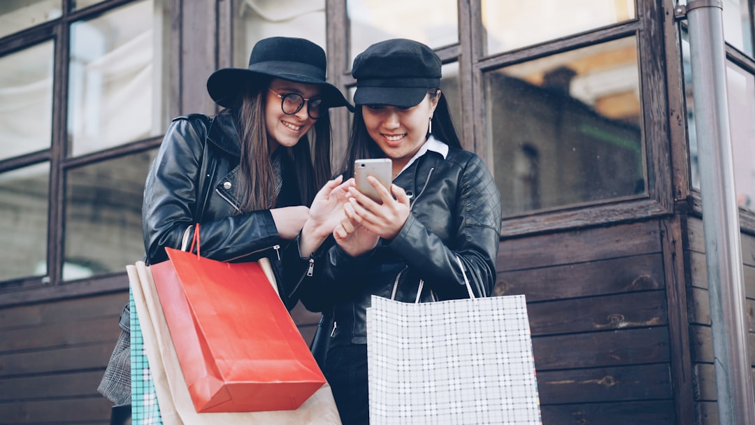 featured-18a15666cf Two women looking at a smartphone with shopping bags