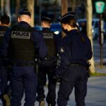 2 police men in police uniform standing on road during daytime