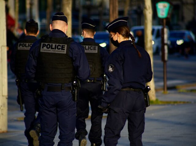 2 police men in police uniform standing on road during daytime